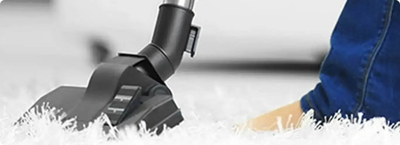 Close-up of a professional vacuuming a white carpet in Sabin.